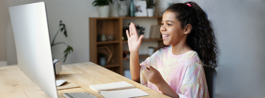 Smiling girl taking lesson online.